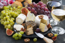 Soft Delicacy Cheeses and Snacks For Wine On A Dark Background, Close-Up