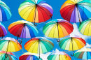 Guarda-chuvas flutuam no céu como arco-íris