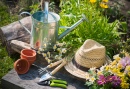 Gardening Tools and A Straw Hat On the Grass In the Garden