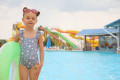 172867909-cute-little-girl-with-inflatable-ring-near-pool-in-water-park-space-for-text