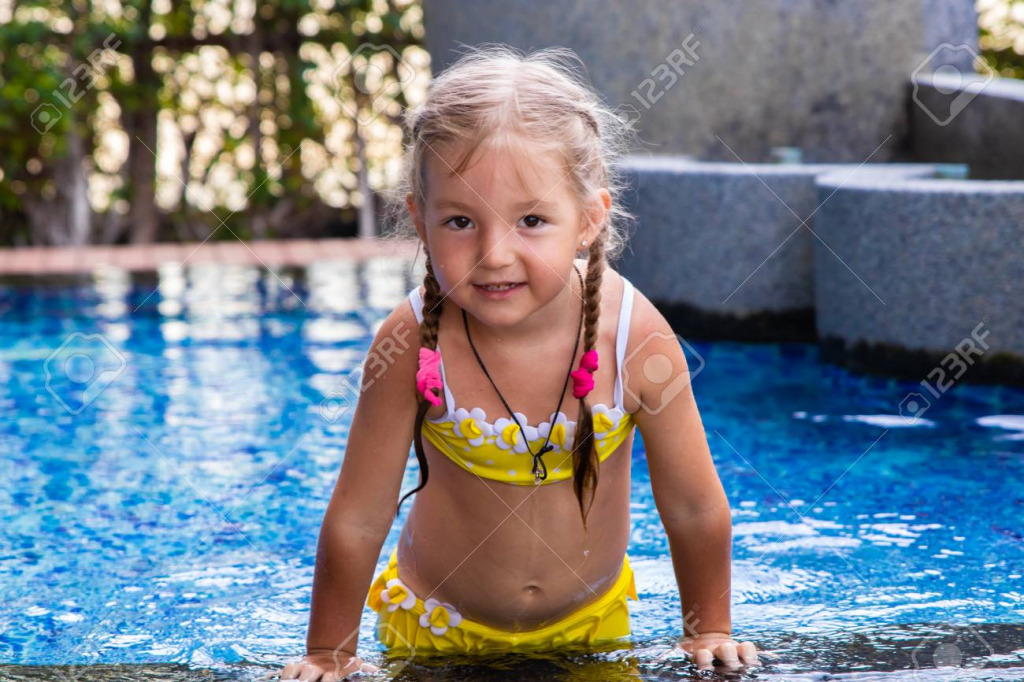 120075948-little-girl-in-a-yellow-swimsuit-in-a-blue-pool-like-a-mermaid-kids-concept-kids-fashion jigsaw puzzle in PJ Hunter puzzles on TheJigsawPuzzles.com