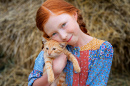 A Freckled Red-Haired Girl with Her Ginger Kitten